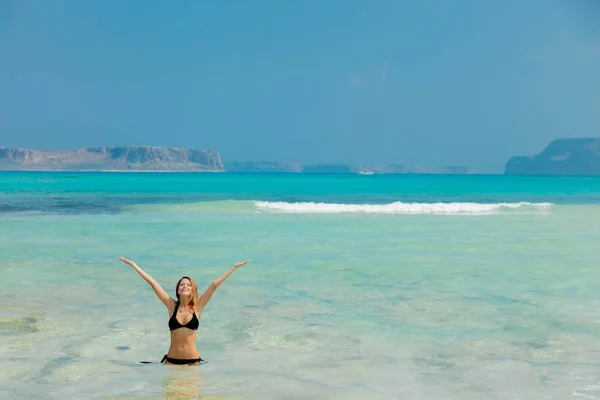 Chica pelirroja joven en bikini negro en la playa de Balos —  Fotos de Stock