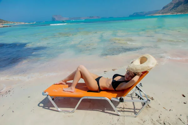 Dívka vleže na lehátku na Balos beach — Stock fotografie