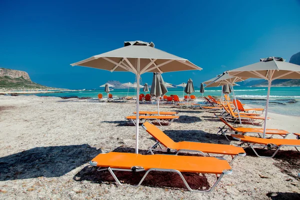 Guarda-sol e espreguiçadeiras na lagoa do mar de Balos — Fotografia de Stock