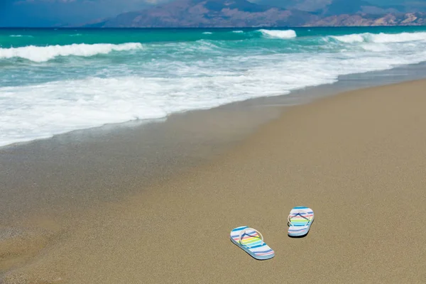 Kolorowe sandały na piasku na plaży — Zdjęcie stockowe