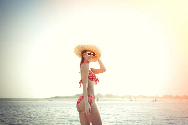 Girl in hat and bikini on Elafonissi beach in sunset — Stock Photo, Image