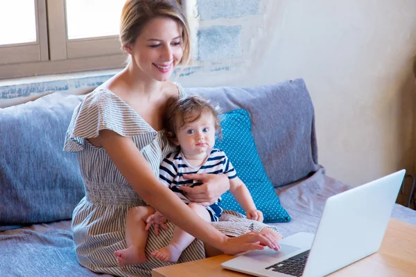 Matka s dítětem pracovat s počítačem doma. — Stock fotografie