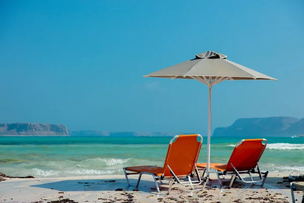 Parasoll och solstolar vid havet lagunen av Balos — Stockfoto