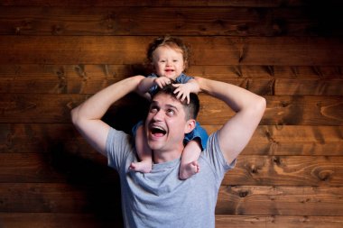 Genç mutlu baba ve çocuk ahşap arka plan omuzlarında üzerinde 