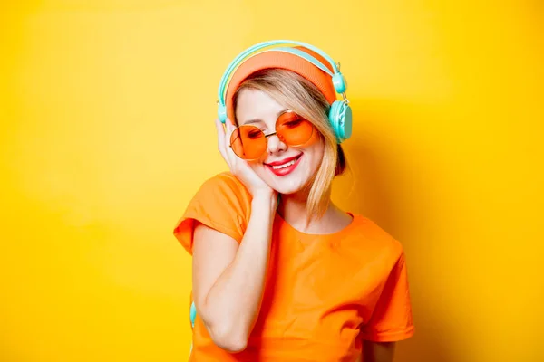 Mladá Žena Stylové Oranžové Brýle Sluchátka Žlutém Pozadí Oblečení Stylu — Stock fotografie