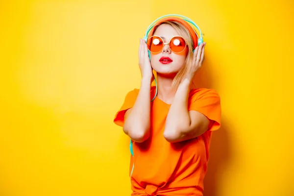 Mujer Joven Elegante Con Gafas Auriculares Color Naranja Sobre Fondo —  Fotos de Stock