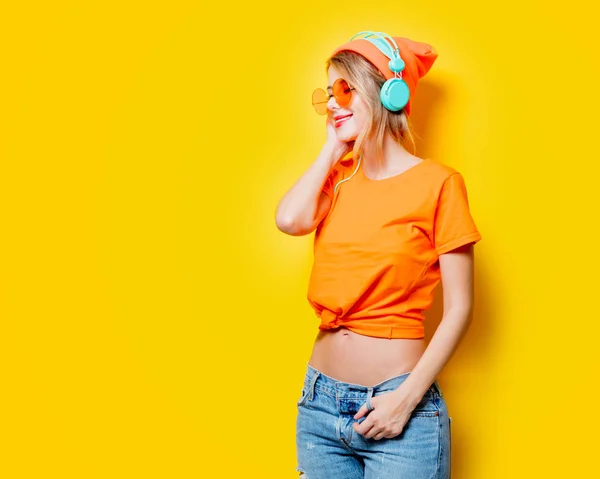 Młoda Kobieta Stylowe Okulary Pomarańczowy Słuchawki Żółtym Tle Ubrania Stylu — Zdjęcie stockowe