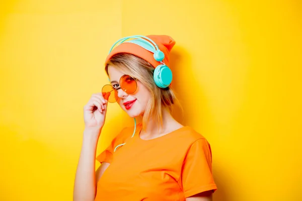 Stijlvolle Jongedame Met Oranje Bril Koptelefoon Gele Achtergrond Kleding Stijl — Stockfoto