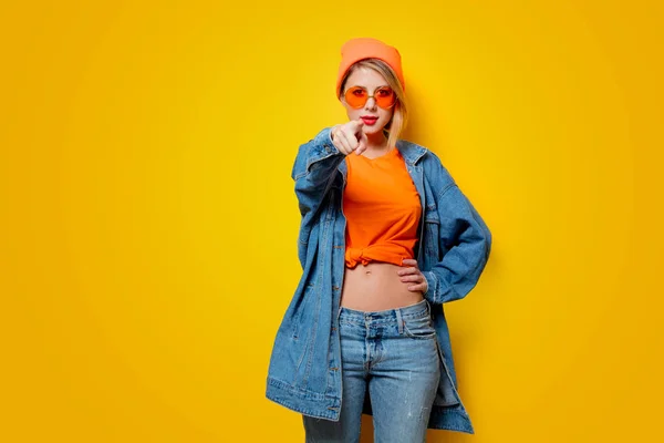 Młoda Atrakcyjna Kobieta Jeans Odzież Okulary Pomarańczowy Żółtym Tle Ubrania — Zdjęcie stockowe