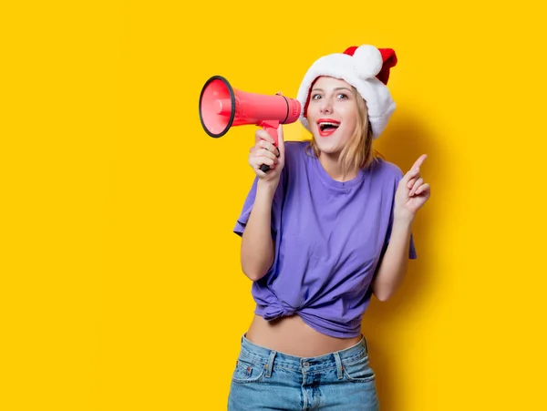 穿着紫色衣服 头戴圣诞帽 背景为黄色 带粉色扩音器的年轻姑娘 象征着女性的反抗1980年代风格的服装 — 图库照片
