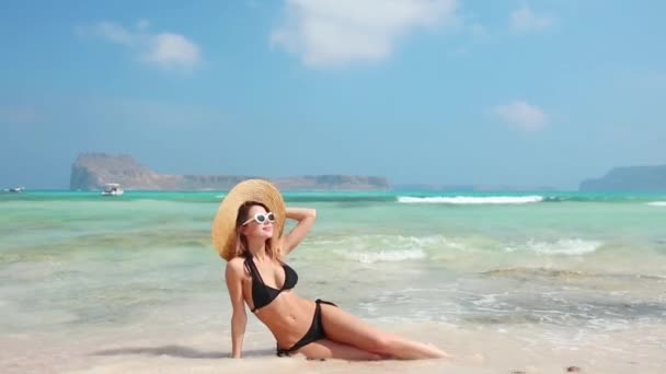 美丽的年轻女子草帽和泳装在沙滩上摆姿势 — 图库视频影像
