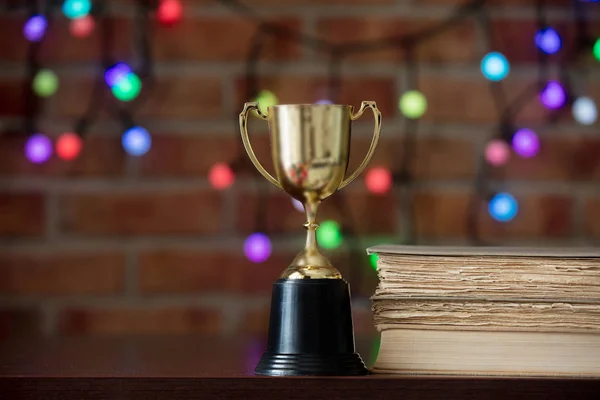 Coppa Oro Libri Tavolo Legno Con Bokeh Sullo Sfondo — Foto Stock