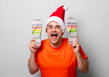 Noel şapka ve sandlas Turuncu tişört genç yakışıklı adam. Beyaz arka plan resmine stüdyo