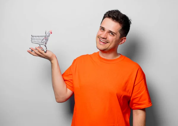 Homem Bonito Jovem Camiseta Laranja Com Carrinho Compras Imagem Estúdio — Fotografia de Stock