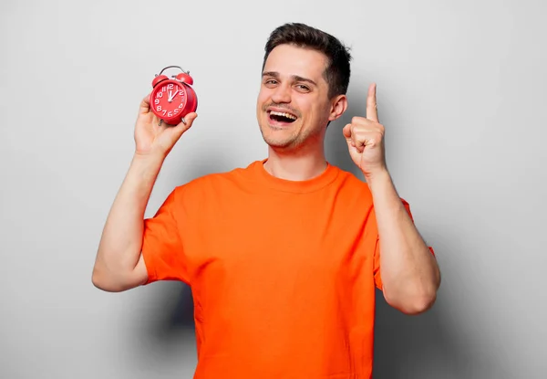 Young Handsome Man Orange Shirt Red Alarm Clock Studio Image — Stock Photo, Image