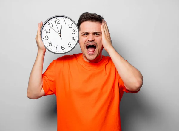 Young Handsome Man Orange Shirt Big Clock Studio Image White — Stock Photo, Image