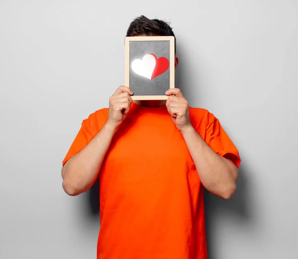 Junger Gutaussehender Mann Orangefarbenem Shirt Mit Kleiner Tafel Und Zwei — Stockfoto