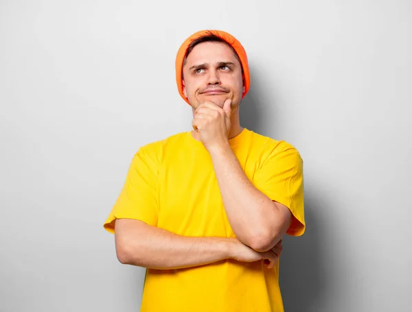 白色背景的黄色 T恤和橙色帽子的年轻英俊男子 — 图库照片