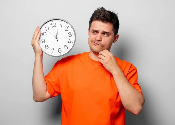 Young Handsome Man Orange Shirt Big Clock Studio Image White — Stock Photo, Image