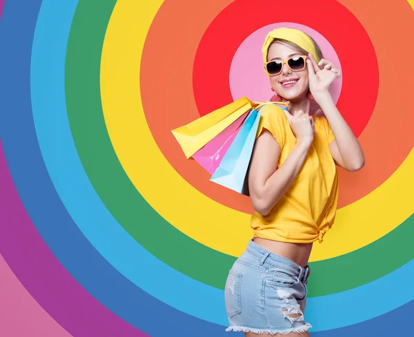 Молодая Счастливая Женщина Желтой Футболке Синих Джинсах Держа Разноцветные Сумки — стоковое фото