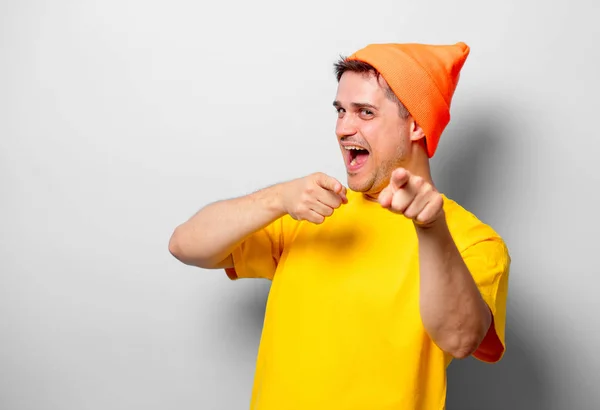 白い背景の上の黄色 シャツとオレンジ帽子の若いハンサムな男 — ストック写真