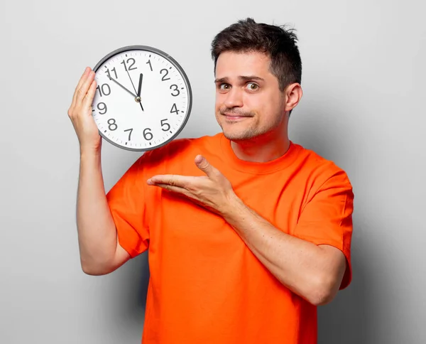 Young Handsome Man Orange Shirt Big Clock Studio Image White — Stock Photo, Image