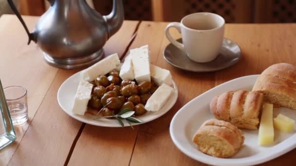 在木桌上看到橄榄 家庭奶酪和法式面包 — 图库视频影像