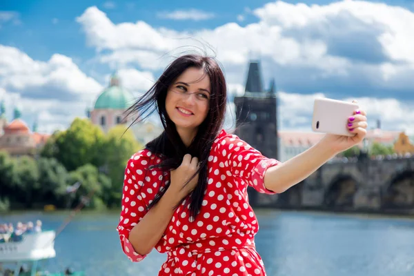 Девушка в красном платье делает селфи в Праге — стоковое фото