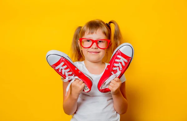 Småbarn flicka i glasögon med joggingskor — Stockfoto