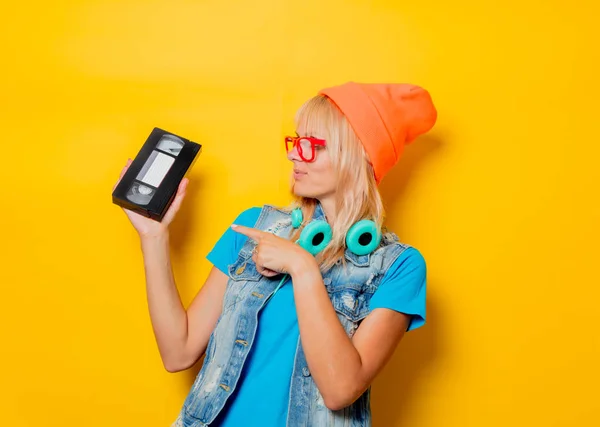 Взрослая девушка оранжевая шляпа с VHS — стоковое фото