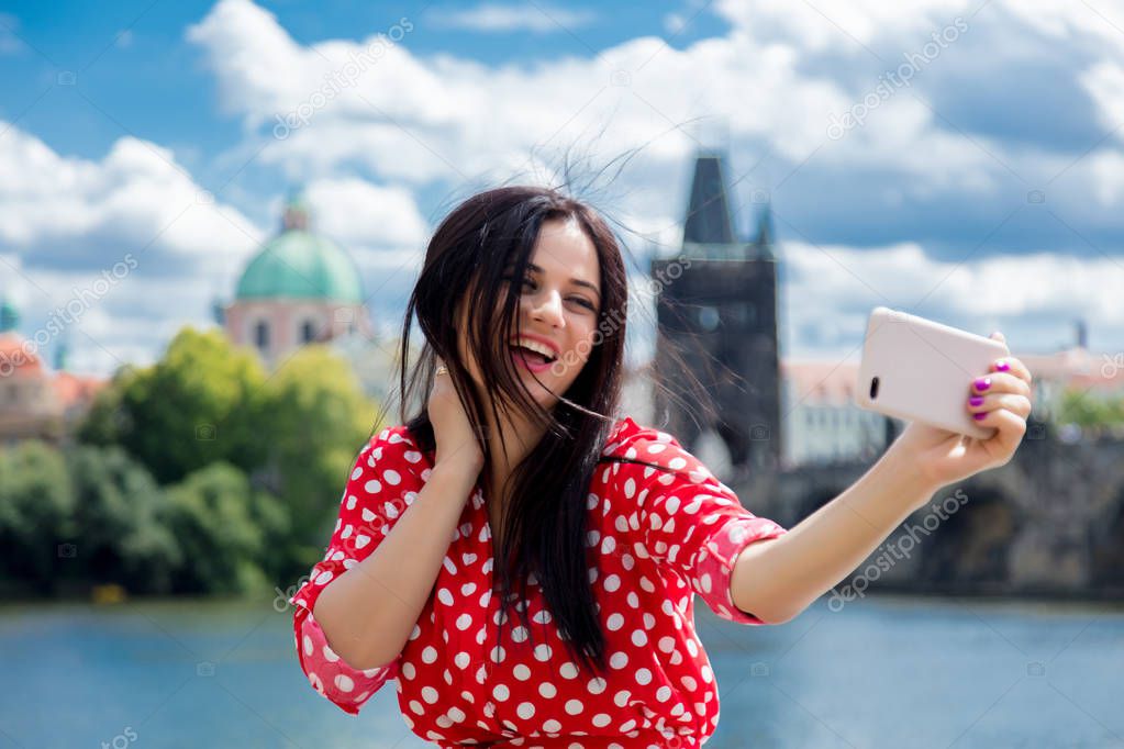 girl in red dress make a selfie in Prague