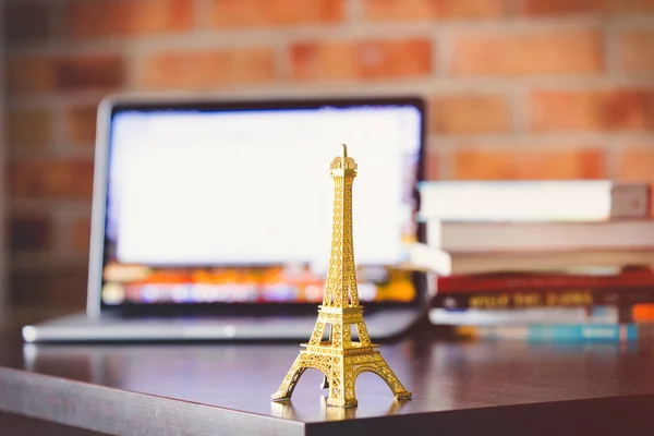 Eiffelova věž na stůl s přenosným počítačem — Stock fotografie