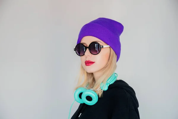 Dziewczyna w fioletowy kapelusz ze słuchawkami — Zdjęcie stockowe