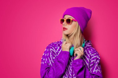 Kulaklıklar, pembe arka plan poz spor ceketli olan kadın