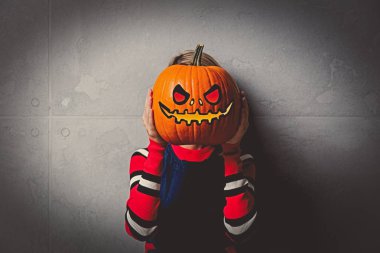 Cadılar Bayramı Balkabağı gri arka plan üzerinde ile kırmızı Çizgili kazaklı genç tarzı sarışın kız portresi.