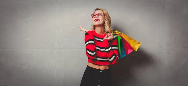 쇼핑백 배경에 포즈와 빨간색 줄무늬 스웨터에서 — 스톡 사진