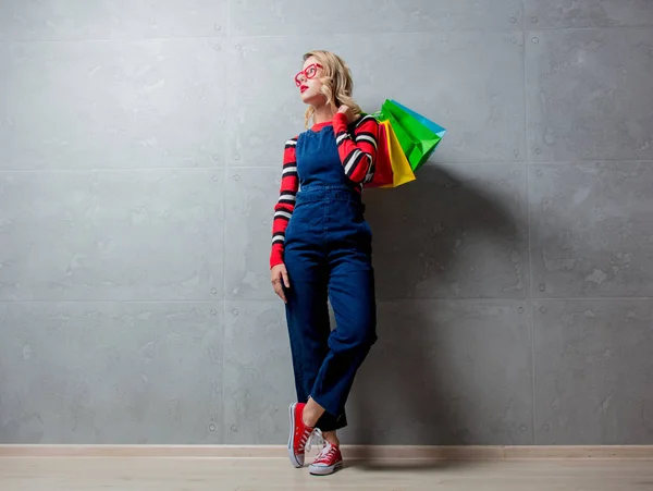 Junges Stilvolles Mädchen Jeans Kleidung Mit Einkaufstaschen Auf Grauem Hintergrund — Stockfoto