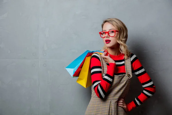 Junges Stilvolles Mädchen Mit Einkaufstaschen Auf Grauem Hintergrund — Stockfoto