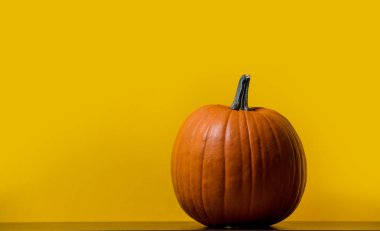 Bir Turuncu kabak sarı arka plan ile masada