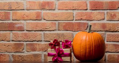 Bir Turuncu kabak ve Hediyelik kutu duvar arka plan üzerinde. Görüntü yan köşe ışık ile