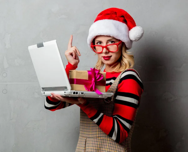 年轻女孩与笔记本电脑和圣诞礼品盒灰色背景 — 图库照片