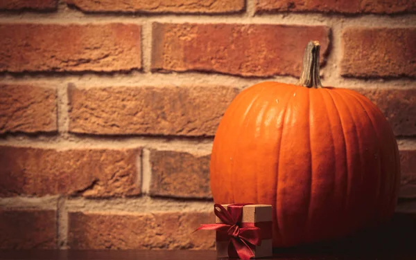 Orange Pumpa Och Present Låda Väggen Bakgrund Bild Med Hörnet — Stockfoto