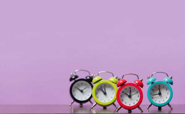 Grupo Relojes Alarma Colores Sobre Fondo Púrpura —  Fotos de Stock