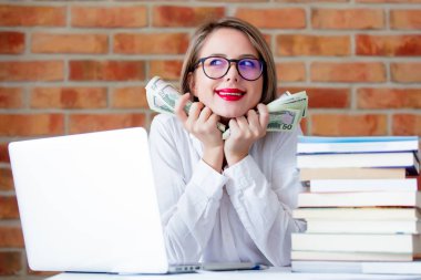 işkadını dizüstü bilgisayar ve elinde para ile