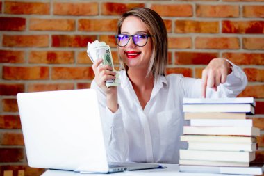 işkadını dizüstü bilgisayar ve elinde para ile