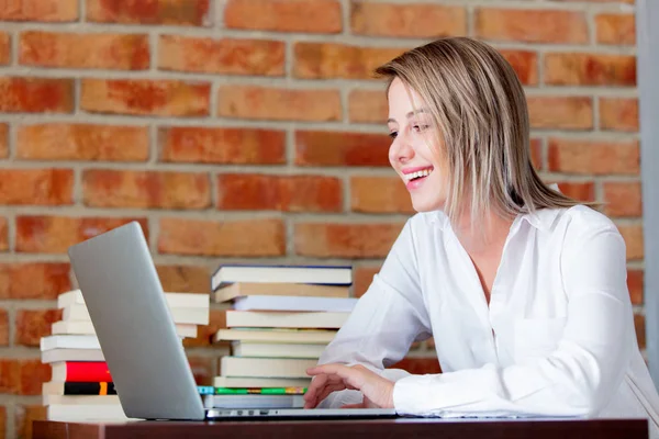 Mujer de negocios con ordenador portátil y libros — Foto de Stock