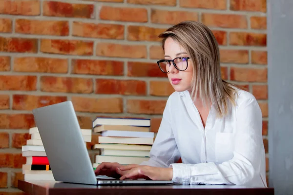 Zakenvrouw met laptopcomputer en boeken — Stockfoto