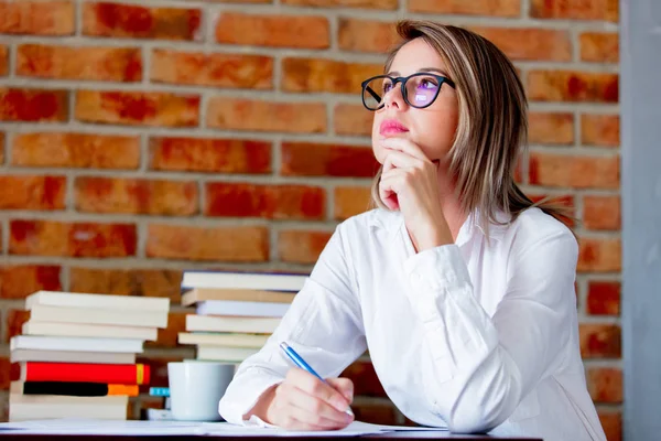 Mujer de negocios con pluma en el lugar de trabajo —  Fotos de Stock