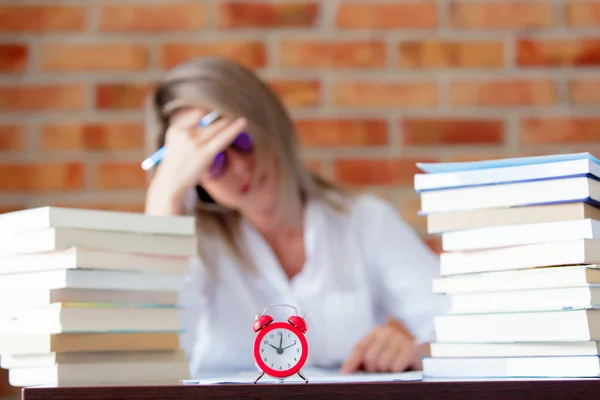 Ragazza in camicia con libri e sveglia — Foto Stock