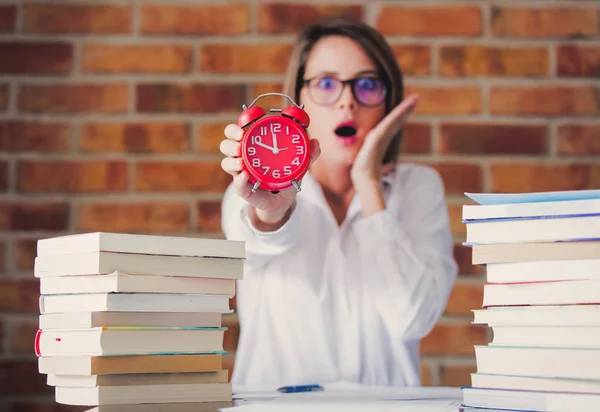 Γυναίκα με βιβλία κρατώντας ρολόι συναγερμών — Φωτογραφία Αρχείου